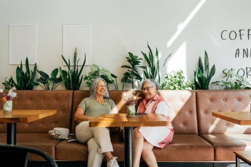 Two female friends chatting while drinking coffee in a cafe