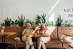 Two female friends chatting while drinking coffee in a cafe